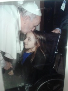 教皇弗朗西斯亲吻伊丽莎白额头的照片，罗马教廷授予伊丽莎白和其他三名从干细胞治疗中获益的孩子和成人荣誉奖章，以鼓励干细胞的应用。